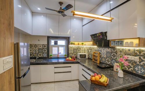 a kitchen with white cabinets and a ceiling fan at Boutique Apartments By One Tree in Jodhpur