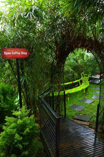 an open gate with a bench in a park at Swiss Holidays in Pinangode