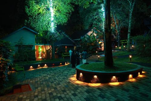 a group of people standing in a park at night at Swiss Holidays in Pinangode