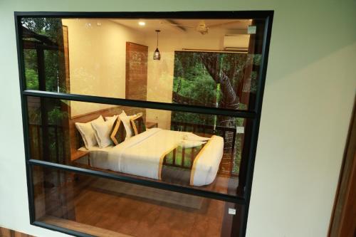 a room with a bed in a glass window at Swiss Holidays in Pinangode