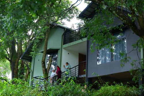 a group of people standing on the balcony of a house at Swiss Holidays in Pinangode