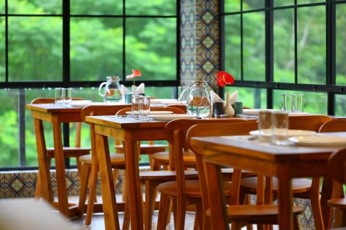 a row of wooden tables and chairs in a restaurant at Swiss Holidays in Pinangode