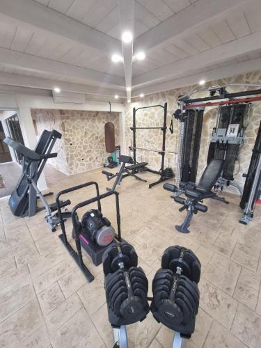 a gym with several exercise equipment in a room at Villa Zagara Pool e Sea in San Pietro in Bevagna