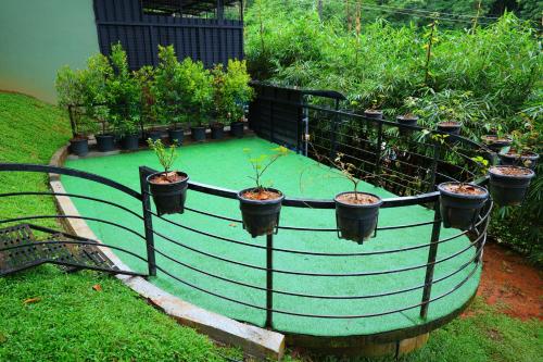 a garden with plants in pots on a fence at Swiss Holidays in Pinangode