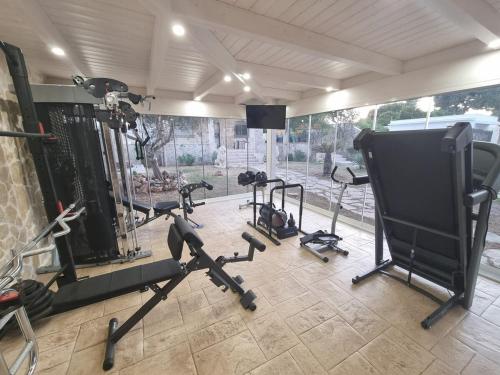 a gym with several tread machines and a large window at Villa Zagara Pool e Sea in San Pietro in Bevagna