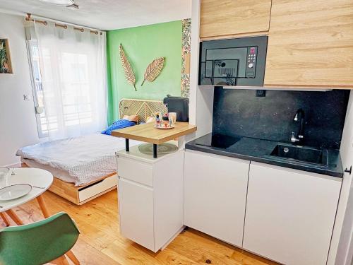 - une petite cuisine avec une table et un lit dans l'établissement 07-1 - Cozy & élégant - TV sat&VOD, à Villeurbanne