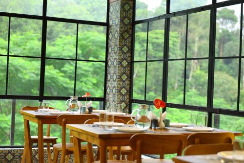 a dining room with tables and chairs and windows at Swiss Holidays in Pinangode