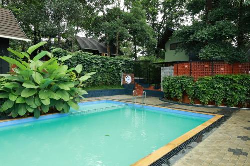 a swimming pool in a yard with plants at Swiss Holidays in Pinangode