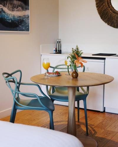 Una mesa de comedor con un jarrón de flores encima. en Résidence Les Suites du Port - by Le Saint Ferdinand, en Arcachon