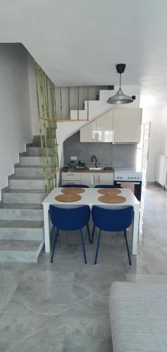 a kitchen with a table and chairs and a staircase at Heracles Guest house in Néa Péramos