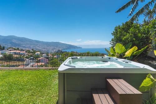a hot tub sitting on top of a grass field at Sublime View Villa by Atlantic Holiday in Funchal