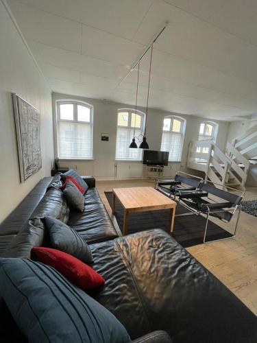 a living room with a leather couch and a table at Kongensgade (ID 161) in Esbjerg