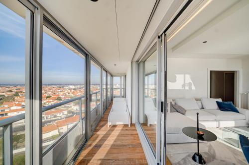 Cette chambre dispose de grandes fenêtres, d'un lit et d'un canapé. dans l'établissement Élégant Penthouse avec Vue Mer Double Garage, à Les Sables-dʼOlonne