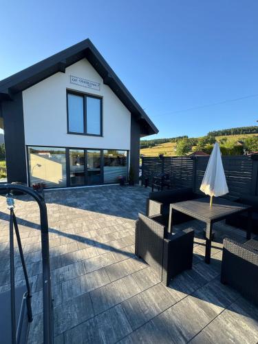 a patio with a table and chairs and a building at Osiedlowa 7 in Tylicz