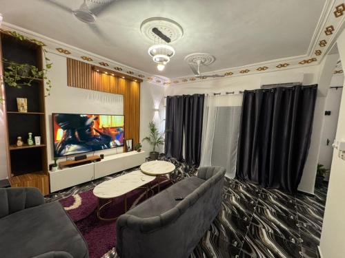 a living room with a couch and a tv at Luxury Nest in Kika