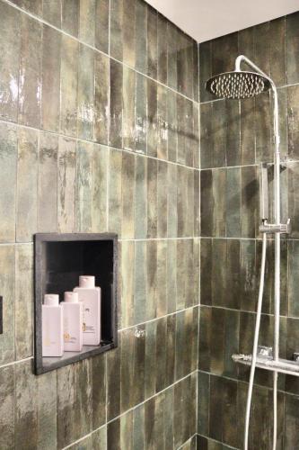 a bathroom with a shower with green tiles at Apartamento Malino in Sagres