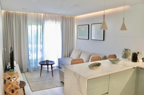 a white living room with a couch and a table at Apartamento Malino in Sagres