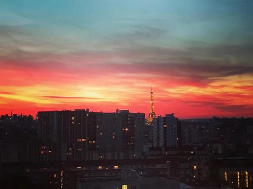 un horizon de ville au coucher du soleil avec une tour en arrière-plan dans l'établissement Confort & Calme 5 pers Rue des Mariniers, à Paris