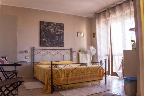 a bedroom with a bed and a table and a window at White Beach in Alghero