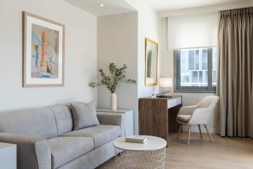 a living room with a couch and a table at Port Tower Piraeus in Piraeus