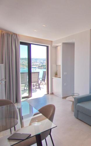 a living room with a blue couch and a glass table at Bay view in town in Chania