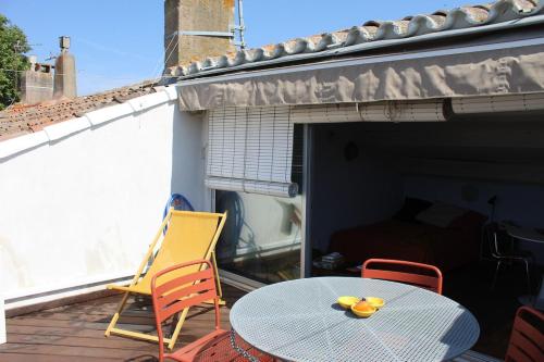 un patio avec une table et des chaises sur un balcon dans l'établissement Duplex climatisé avec terrasse, à Agde