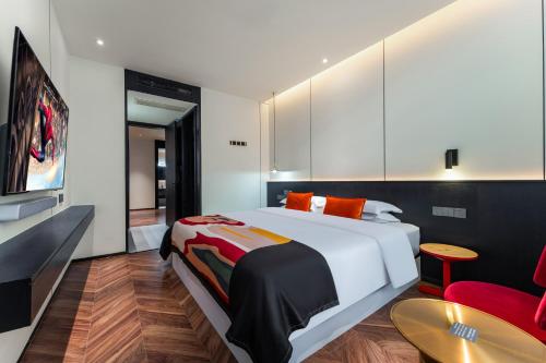 a bedroom with a large white bed and a red chair at HeSu Hidden Art Hotel & Suites - Near Bell Tower & Ideal Location-Spacious rooms featuring King or Double Queen beds -Exclusive Two&Three-Bedroom Suites with Expansive Living Rooms for Group Gathering-Kitty Cuddles & Coffee Gift -Seamless Journey Planning in Xi'an