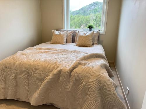 a bed in a room with a window at Exclusive penthouse apartment near the sea and nature - Sæbøvik in Sæbøvik