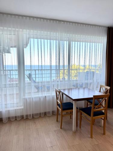 ビャラにあるByala sea view apartment Studioのテーブルと椅子と大きな窓のあるダイニングルーム