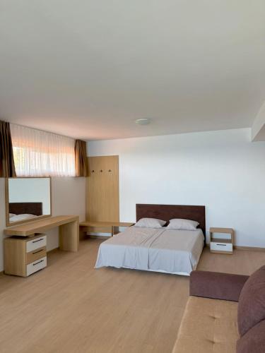 Habitación grande con cama y escritorio. en Byala sea view apartment Studio, en Byala