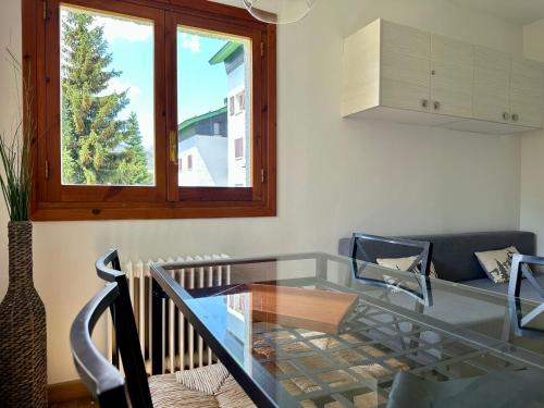 a glass table in a living room with a window at Izas · Pirineos360 · Práctico y sencillo · Perfecto para esquiadores in Formigal