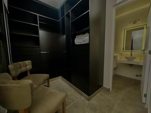 Un baño con una silla, un lavabo y un espejo. en El Recodo del Cerro Apart 1, en Salta