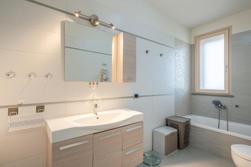 a bathroom with a sink and a toilet and a mirror at Villa Angela in Capannori