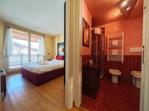 a hotel room with a bed and a bathroom at Hostdomus - Nube d'Argento in Sestriere