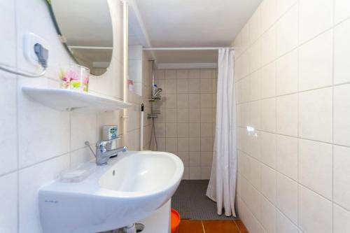 a white bathroom with a sink and a shower at 2BR Lavender Hideaway House by NW in Cserszegtomaj