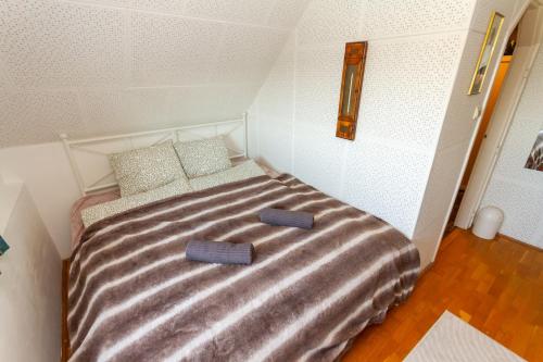 a small bedroom with a bed with two slippers on it at 2BR Lavender Hideaway House by NW in Cserszegtomaj