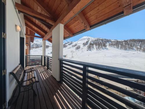 a balcony with a bench and a snowy mountain at Hostdomus - Nube d'Argento in Sestriere