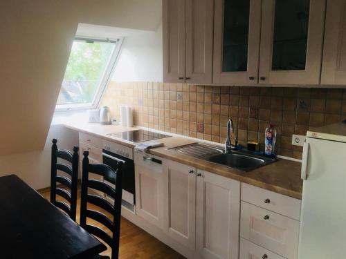 a kitchen with white cabinets and a sink and a window at Ferienglück Lindwedel in Lindwedel