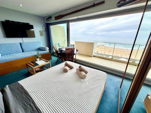 a bedroom with a bed and a view of the beach at Ocean View 2 in Lacanau