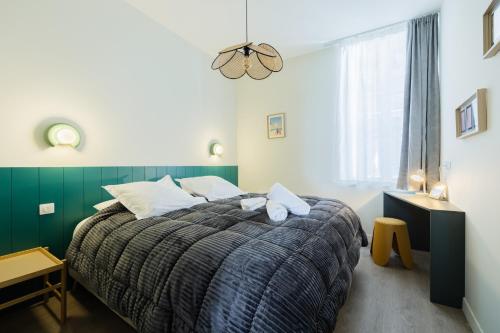 a bedroom with a large bed with a green wall at Appartement 2ch Tout Neuf a Deux Pas du Vieux Port in La Rochelle