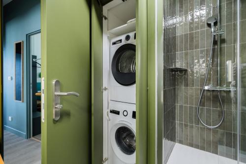 a bathroom with a washer and dryer in a room at Appartement 2ch Tout Neuf a Deux Pas du Vieux Port in La Rochelle