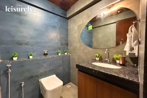 une salle de bain avec un lavabo, des toilettes et un miroir dans l'établissement StayLeisurely The Leisure Lab 5BHK, Khopoli, à Jambhulpāda
