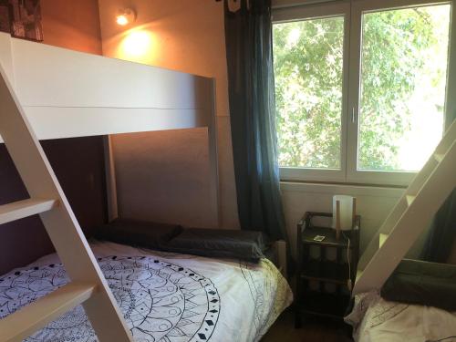 a bedroom with a bunk bed and a window at Liber'Terre in Andouque