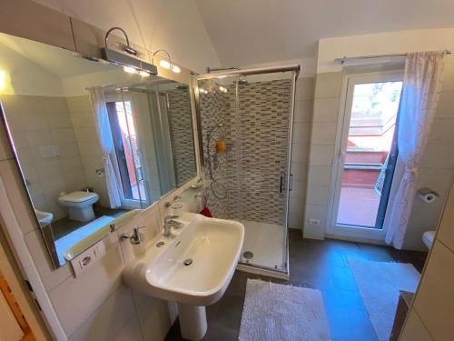 a white bathroom with a sink and a shower at Casa Maia in Baveno