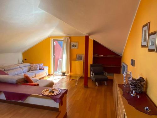 a living room with yellow walls and a couch at Casa Maia in Baveno
