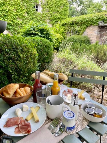 a picnic table with food and bread on it at Chambre d'hôtes - Suite familiale accès privatif in Sacquenay