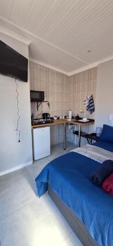 a bedroom with a bed and a kitchen in it at 30 On Dijon Room2 in Gqeberha