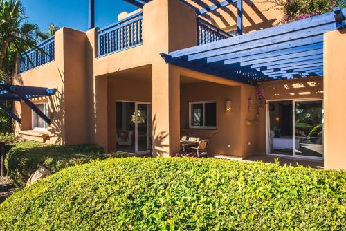 a house with a hedge in front of it at Paradis Plage Surf Yoga & Spa in Taghazout