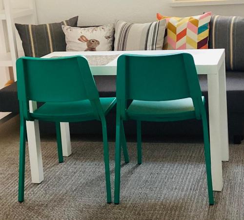two green chairs sitting next to a table with a couch at Pension SPORT-SCHMIEDE in Schmiedefeld am Rennsteig