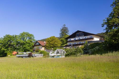 a large building in the middle of a field at Hotel Garni Wurzer in Velden am Wörthersee
